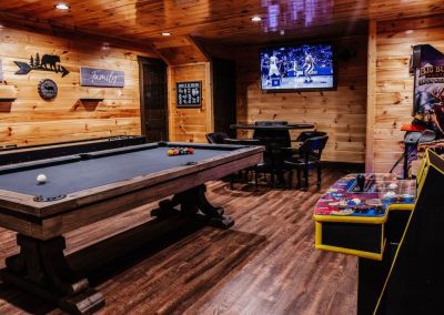 Carmel presidential pool table, poker table, and Big Buck arcade machine in cabin game room